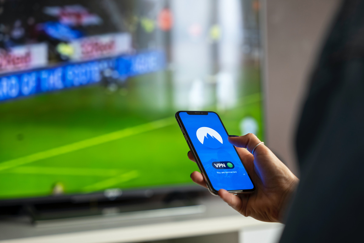 Teléfono utilizando un VPN con futbol de fondo